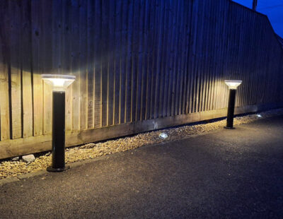 Solar powered bollar lights on footpath with wooden fence in the background
